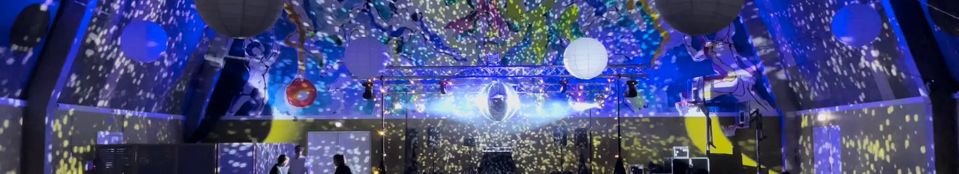 Festlokale med lysrigg i travers, discokule og prosjektorlys over dansegulvet